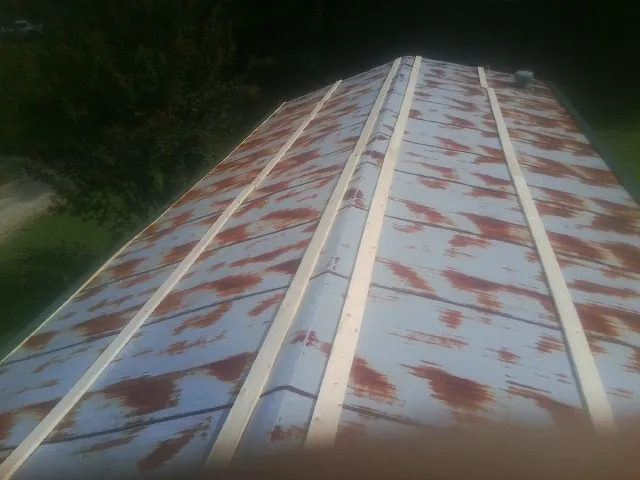 Rusted metal roof panels with new wood purlins before replacement — Storm Damage Roof Repair in Slater by Roofing Brothers